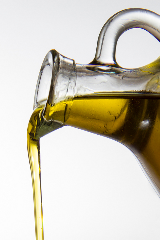 pouring oil from a glass container