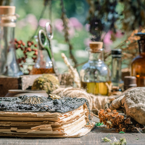Bottles of oil and herbs in the background
