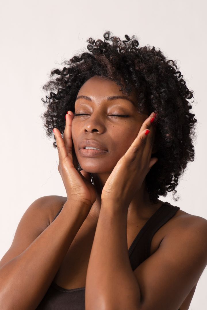 african woman with hands on her face