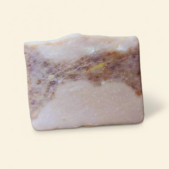 Rectangular bar of soap with natural brown and beige coloration on a light beige background