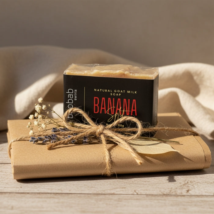 Bar of soap with 'banana' flavor packaging on a wooden surface with a beige towel in the background.