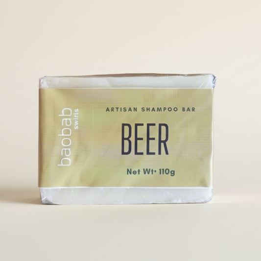 Beer shampoo bar packaging with 'baobab swirls' branding on a beige background