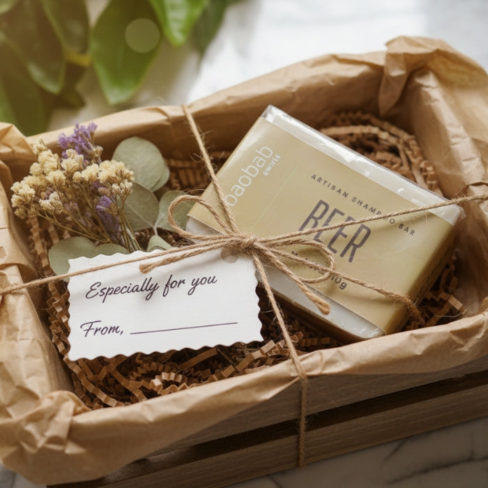 Bar of soap in a decorative box with a card, tied with twine, on a light background.
