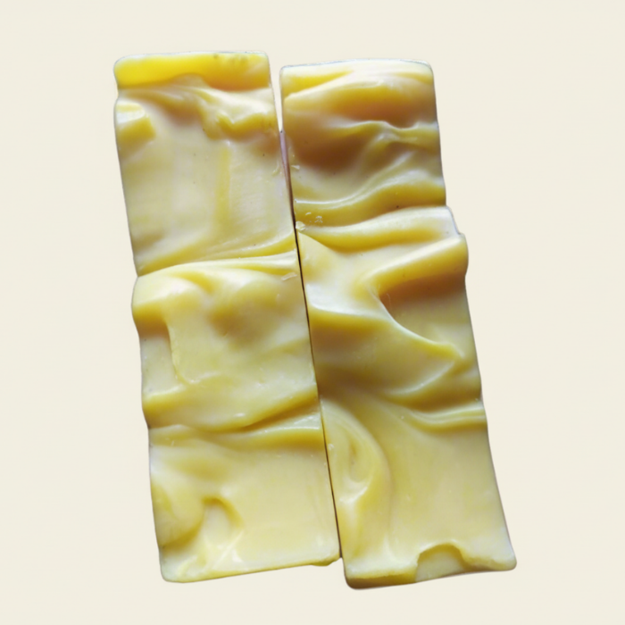 Two bars of calendula soap with a wavy pattern on a beige background