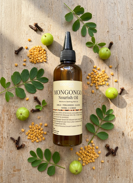 Bottle of Mongongo Nourish Oil on a gray background