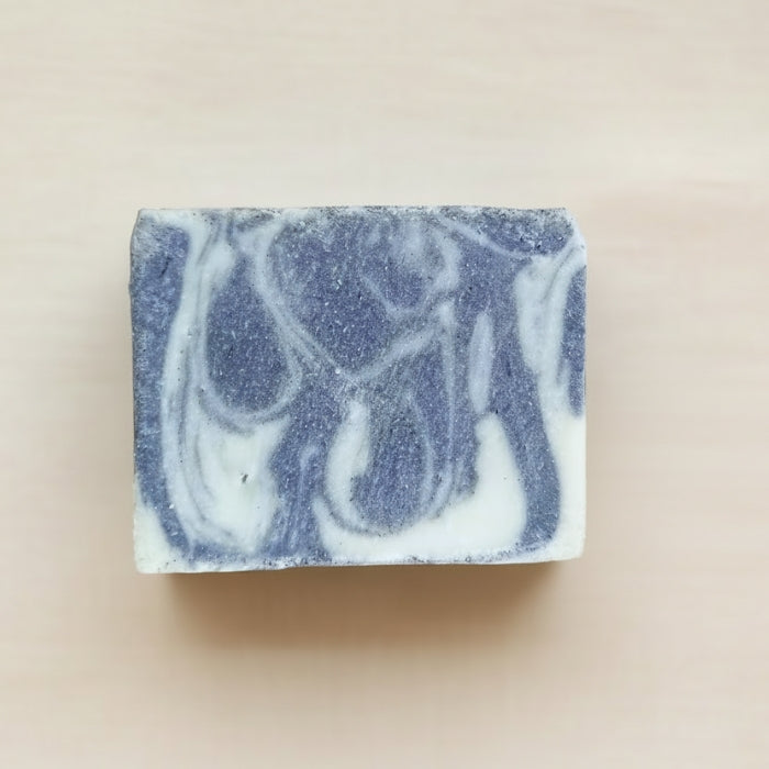 Marbled blue and white soap bar on a beige background