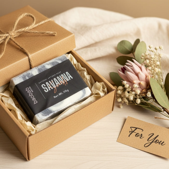 Bar of soap in a brown gift box with decorative elements on a beige surface